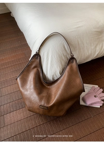 Detailed view of vintage brown PU leather tote bag with natural grain texture and logo