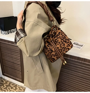 Détail du sac seau à imprimé léopard avec poignée en cuir nouée et fermeture à cordon