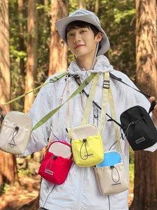 Sacs à bandoulière minimalistes pour gourdes en cinq couleurs dans un décor de forêt