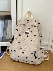 Quilted beige corduroy backpack with black bow print and adjustable side drawstrings