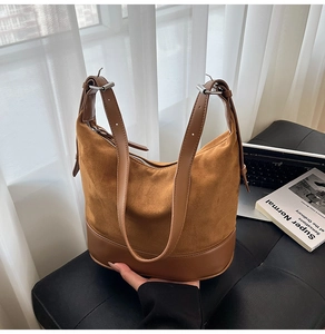 Dettaglio borsa a secchiello in pelle scamosciata marrone con fibbie in metallo argento