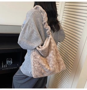 Plush shoulder bag in oat beige featuring a ruffled strap shown on a model