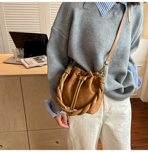 Sac seau en daim marron avec poignée tressée et cordon de serrage en scène de vie
