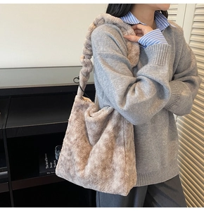 Detail of soft beige faux fur tote bag showing the plush texture and curved fuzzy handle