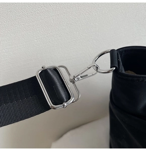 Detail of silver metal D-ring and spring hook on black nylon tote shoulder strap