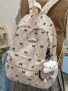 Beige corduroy backpack with black bow patterns and cloud plush charm for school use