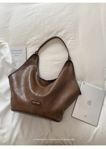 Detail view of a vintage dark brown Hobo shoulder bag with leather texture and brand tag