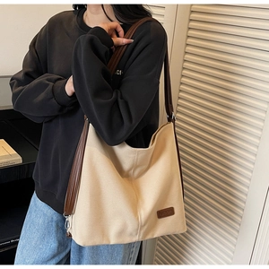 Detail view of large canvas tote bag with brown leather straps and vintage style