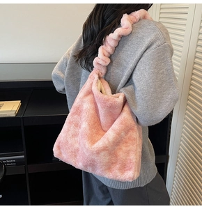 Detail of pink plush faux fur tote bag featuring a textured ruched fluffy shoulder strap