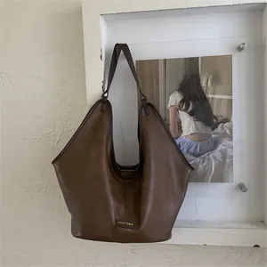 Close-up of vintage brown leather Hobo tote showing fine texture and logo detail