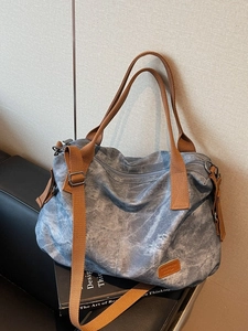 Large blue-grey canvas tote bag with brown woven straps and marble texture effect