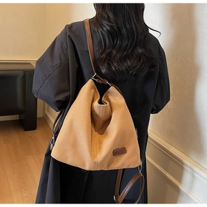Detailed view of the camel canvas tote bag with brown adjustable straps and logo label