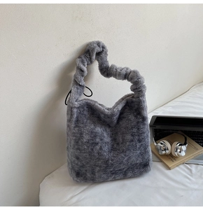Detailed close-up of grey plush faux fur texture on a stylish cloud-style handbag