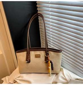 Close-up of leopard tote detail with brown leather trim and beaded charm decoration