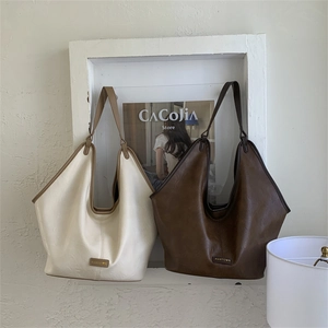 Close-up of beige and dark brown Hobo bags featuring PANTOR metallic logos and soft leather