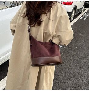 Secchiello marrone scuro in pelle e scamosciato indossato da modella con trench beige
