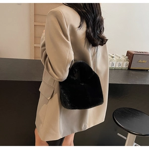 Chic black faux fur bucket bag with silver chain strap shown in lifestyle shot