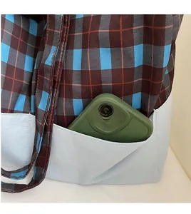 Détail d'un sac cabas à carreaux montrant une poche latérale pratique pour téléphone portable