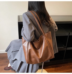 Minimalist caramel brown PU leather tote bag shown on shoulder for a chic commute look