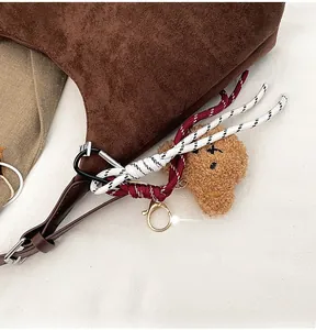 Détail du cabas en daim marron avec pendentif ours en peluche et corde tressée