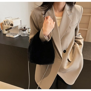 Chic black faux fur chain handbag styled with a beige oversized blazer in a cafe