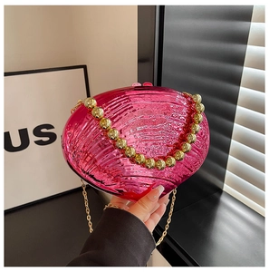 Detail of rose red shell-shaped evening clutch bag with gold beaded handle and chain