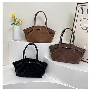 Three large leopard print suede tote bags in brown and black displayed on white stairs