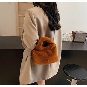 Detailed texture of brown faux fur bucket bag with metallic chain strap for winter