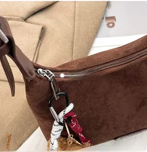 Détail de la fermeture éclair argentée avec cordon coloré sur un sac cabas en daim brun
