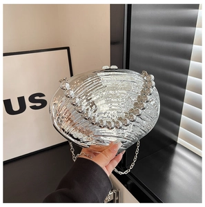 Detail of silver shell-shaped evening bag with pleated texture and pearl bead handle