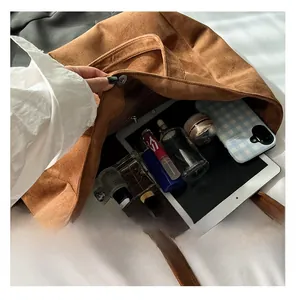 Interior view of large brown suede tote bag showing spacious capacity for electronics
