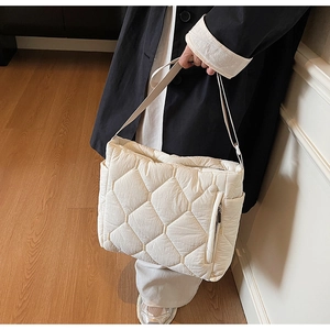 Top view of cream quilted tote bag with large diamond stitching and metallic zipper