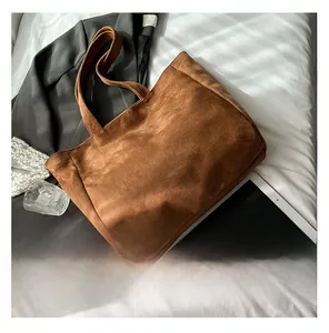 Brown suede tote bag shown with tablet and blazer in a stylish lifestyle arrangement
