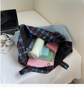 Intérieur spacieux d'un sac cabas à carreaux contenant tablette, parapluie et bouteille d'eau