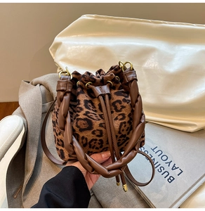Détail du sac seau léopard avec poignée en cuir torsadée et fermeture par cordon de serrage