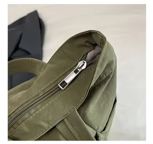 Detail of silver metal zipper on green canvas tote bag with high-density fabric texture