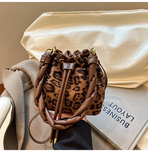 Détail du sac seau léopard avec poignée en cuir tressé et fermeture par cordon