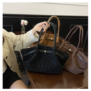 Gros plan de grands sacs cabas à imprimé léopard en noir, café et camel texturé