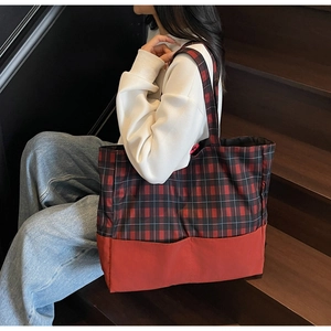 Grand sac cabas à carreaux rouge et noir sur un escalier montrant son volume généreux