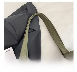 Close-up of olive green tote bag showing reinforced shoulder strap stitching and fabric texture