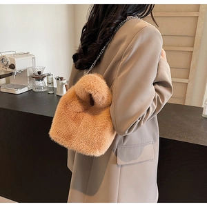 Detail of camel faux fur bucket bag featuring premium metal chain and plush texture