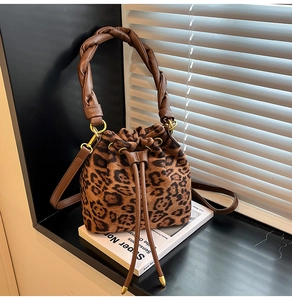 Vue détaillée du sac seau en daim léopard avec poignée en cuir torsadé et cordon de serrage