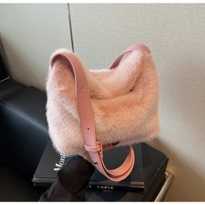 Dettaglio della borsa a secchiello in ecopelliccia rosa con tracolla in pelle regolabile
