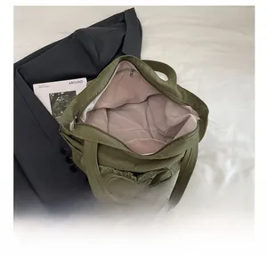 Detail view of olive green canvas tote bag featuring pleated bow design and pink lining