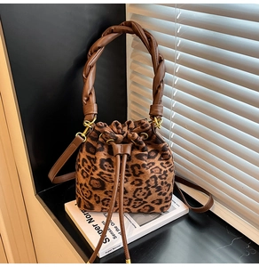 Détail du sac seau léopard avec poignée en cuir tressé et fermeture à cordon