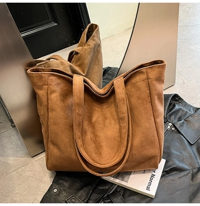 Detail of a brown suede tote bag with long straps and large capacity for women