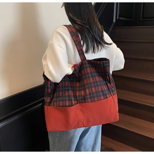Détail du sac cabas à carreaux rouge et noir montrant sa grande capacité pour le bureau