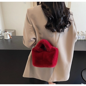 Detailed close-up of a red faux fur bucket bag with a stylish silver metal chain strap