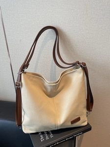 Minimalist beige canvas tote bag with adjustable brown leather straps for daily commute