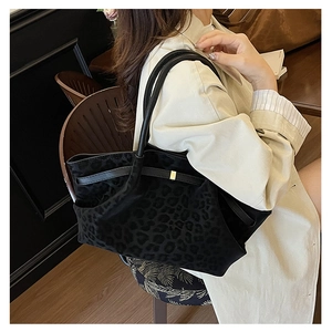 Close-up of leopard print suede texture and gold metal buckle on a large tote bag